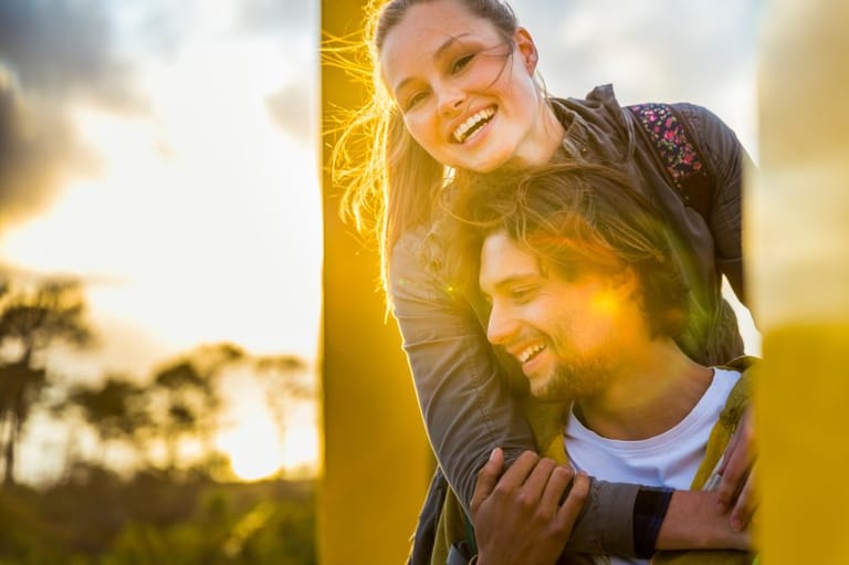 Couple on hike smiling while resting