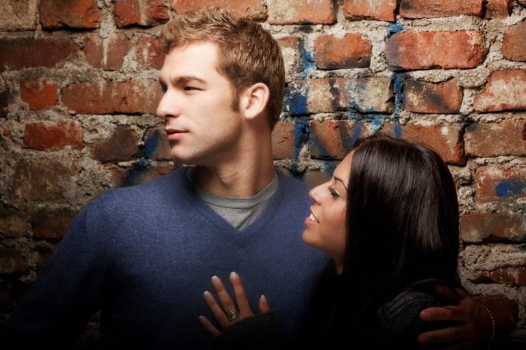 Biracial couple near wall