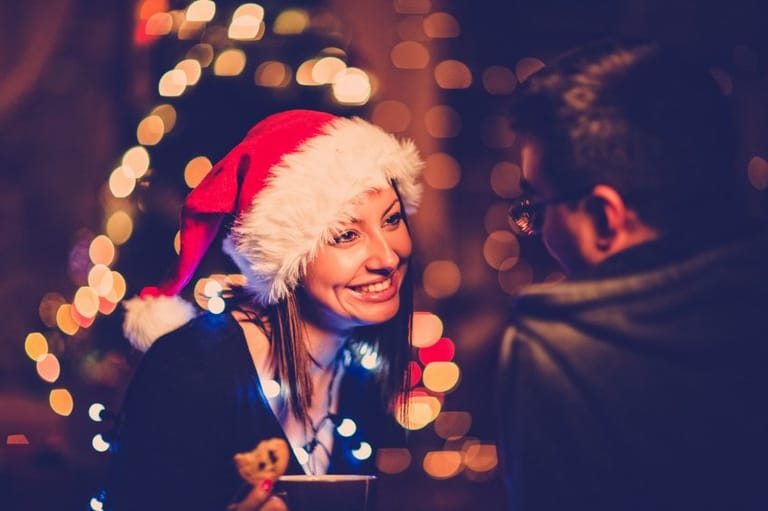 Girl in Santa hat talking to a friend.