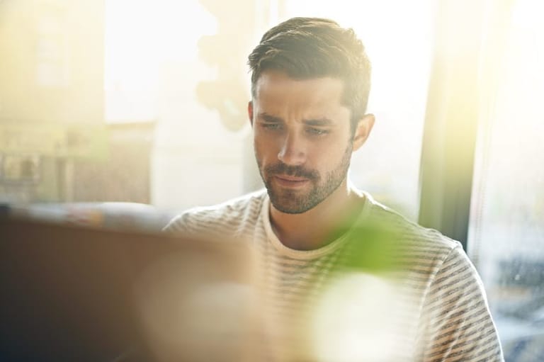 Handsome young man with beard on laptop
