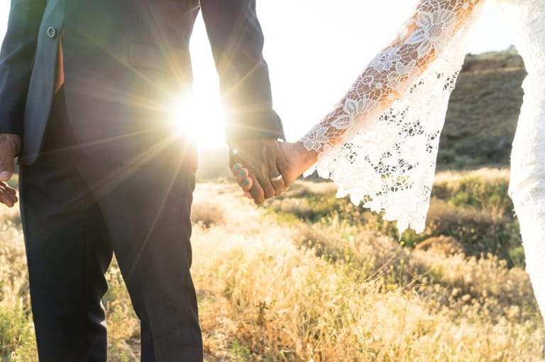 Married couple holding hands in the sunset