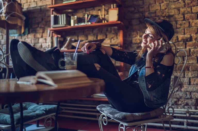 Young hipster woman enjoying in a sound from seashell