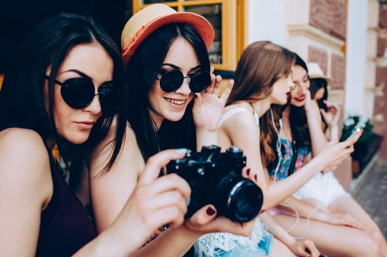 Two beautiful young girls are holding vintage camera