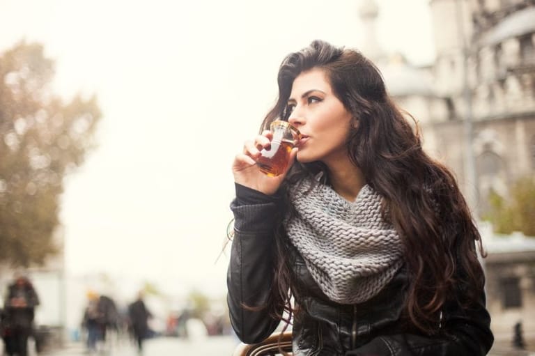 Woman drinking and walking