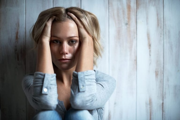 Blond sitting crying mascara smudged