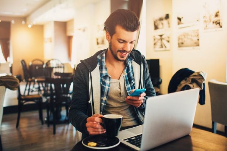 Guy sat with laptop and phone