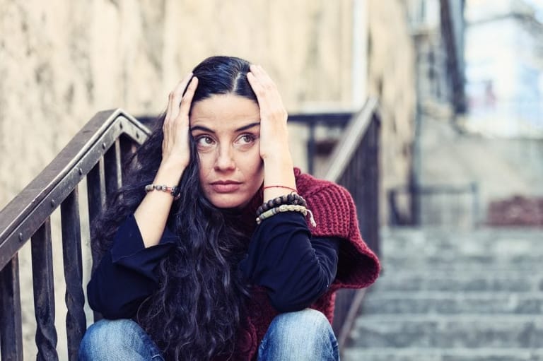 Woman sat on steps head in hands