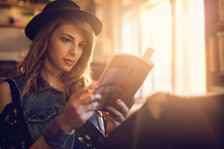 Young hipster woman relaxing while reading a book.