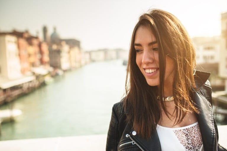 smiling woman overlooking italian canal