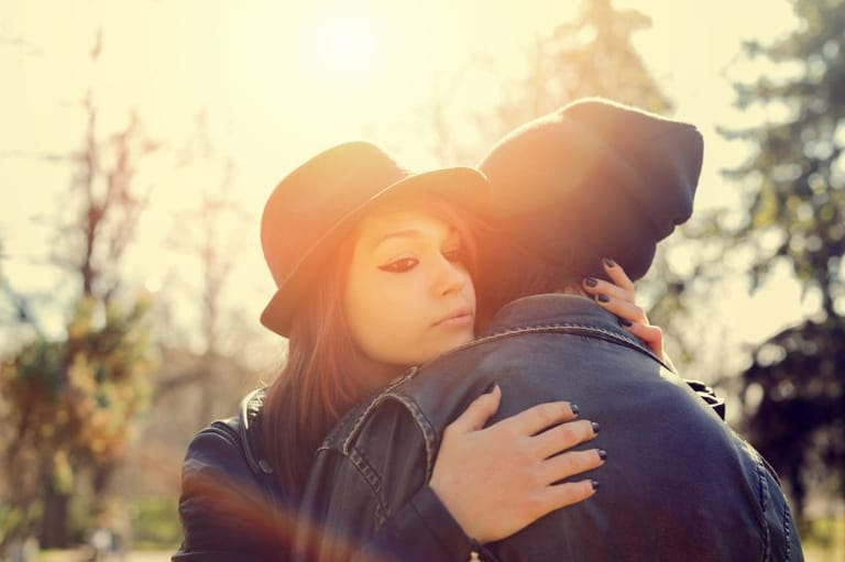 woman embracing boyfriend sunlight