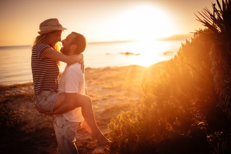 couple laughing sunset beach