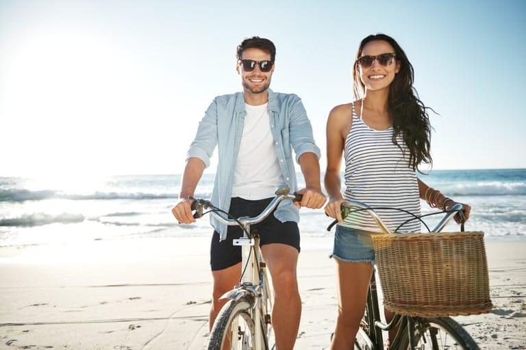 happy couple bikes beach