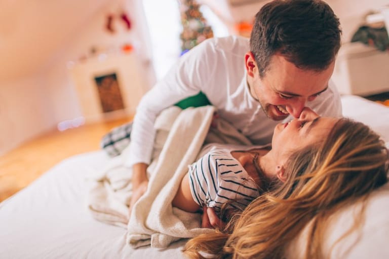 couple laughing bed happy
