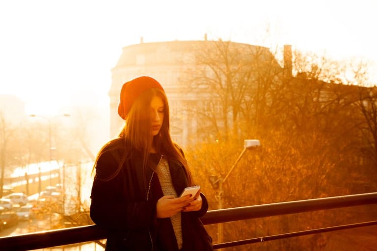 woman texting at sunset in paris