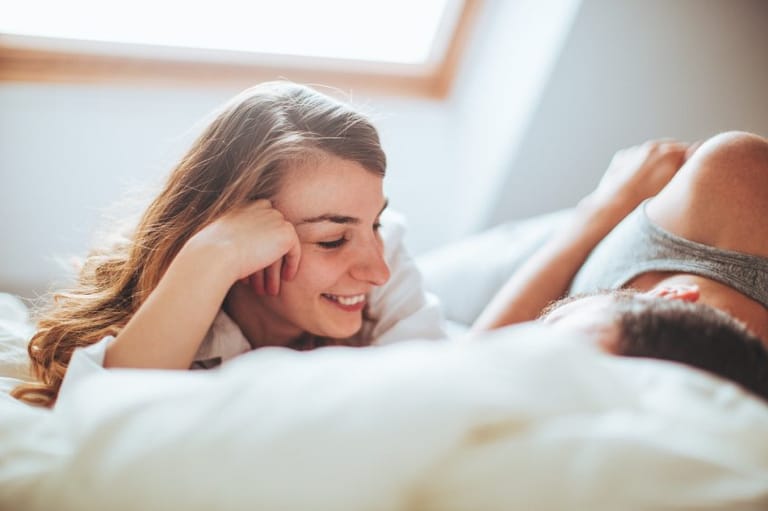 couple sex bed laughing