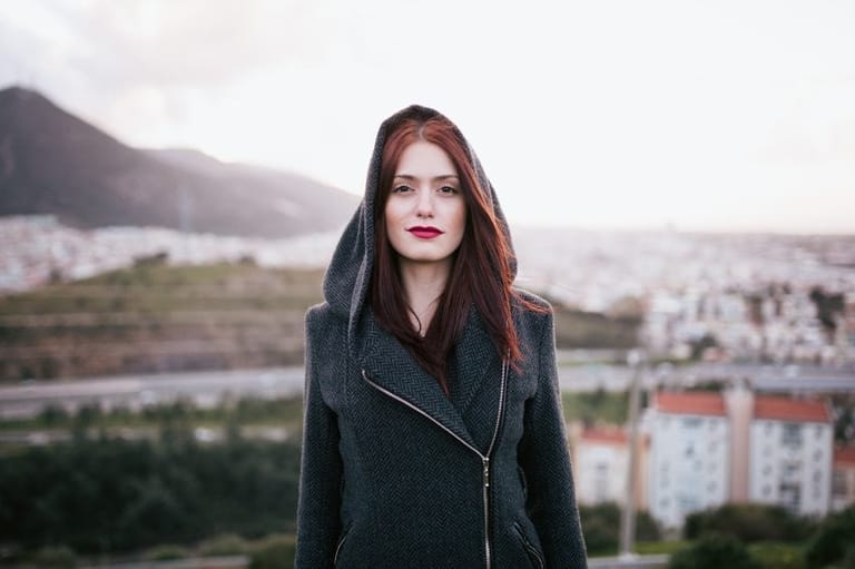 woman on rooftop staring hood up