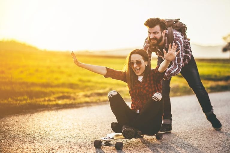 man woman friends sun skateboard