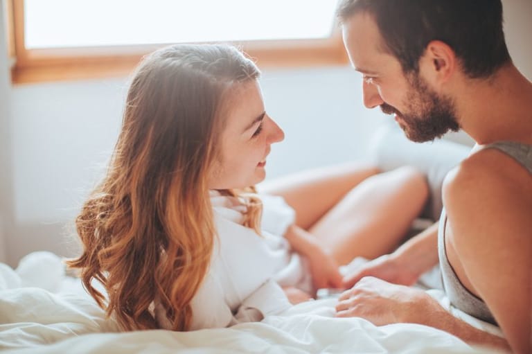 Young couple talking in bed