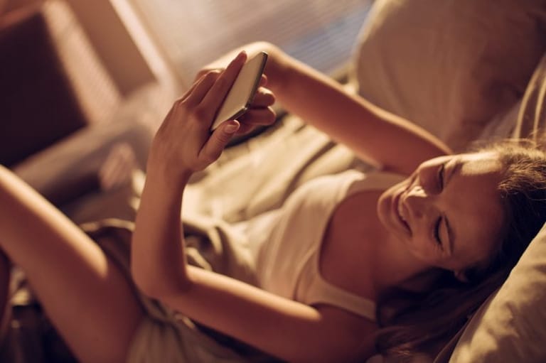 woman taking selfie in bed