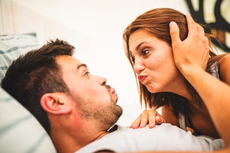 man woman bed funny faces