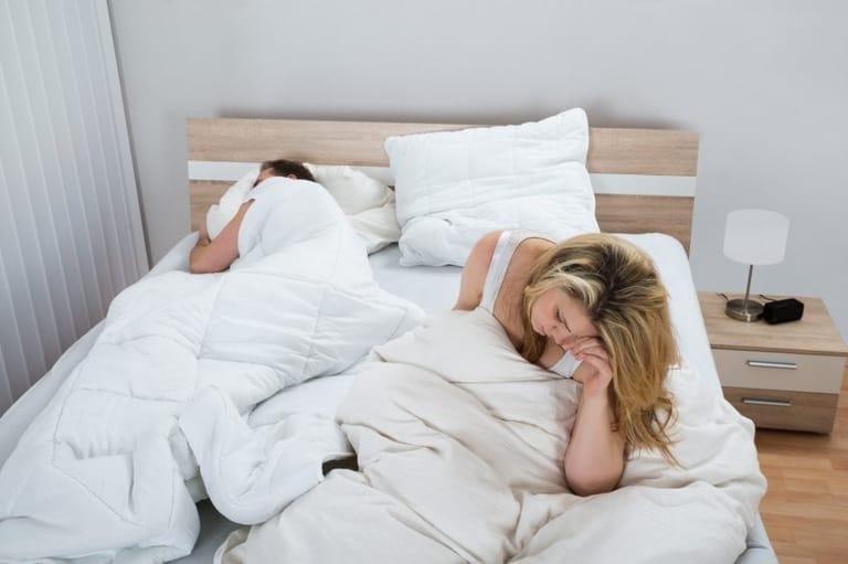 woman frustrated bed sleeping man