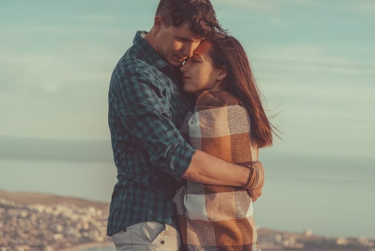 Young man embraces a woman outdoor