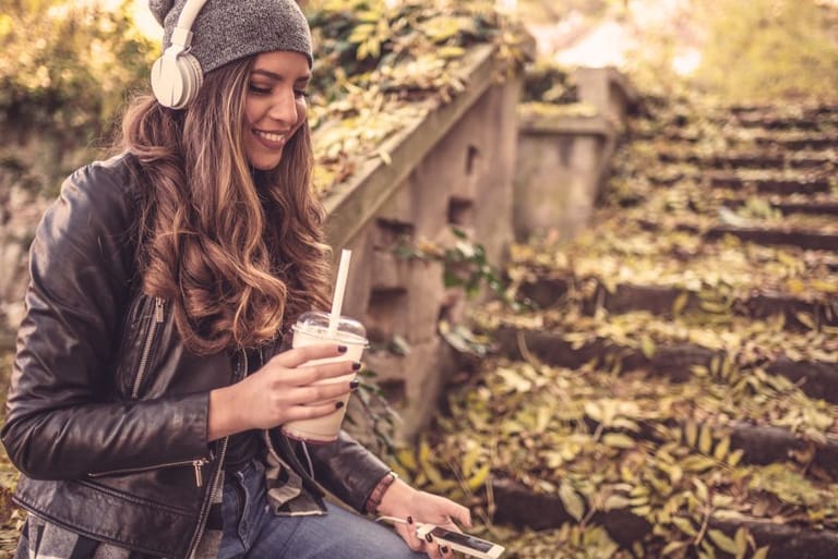 woman wearing headphones drinking