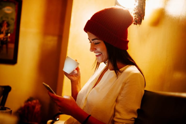 woman drinking coffee while texting