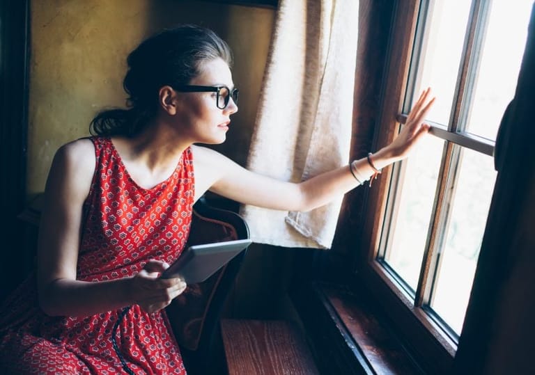 Hipster woman looking out window
