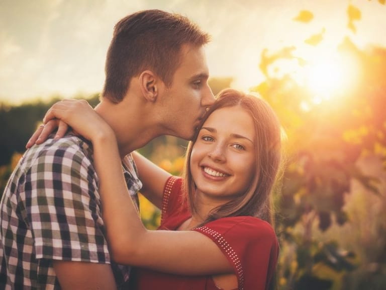 couple smiling field sunset
