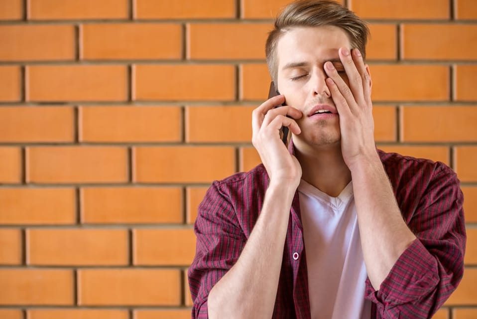 Young man frustrated on his phone.