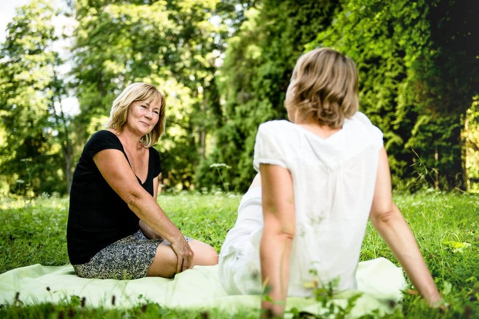 Woman sitting outdoors together having a chat.