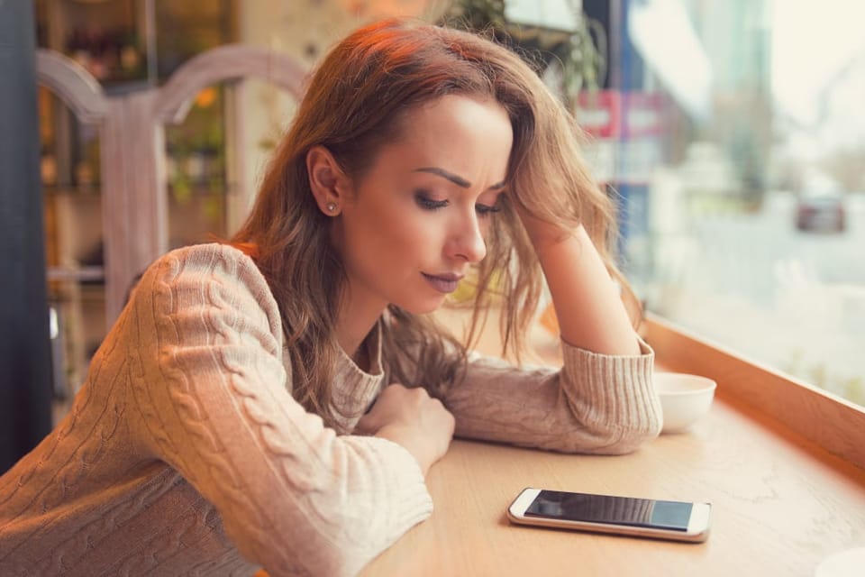 Woman sitting alone looking sad.