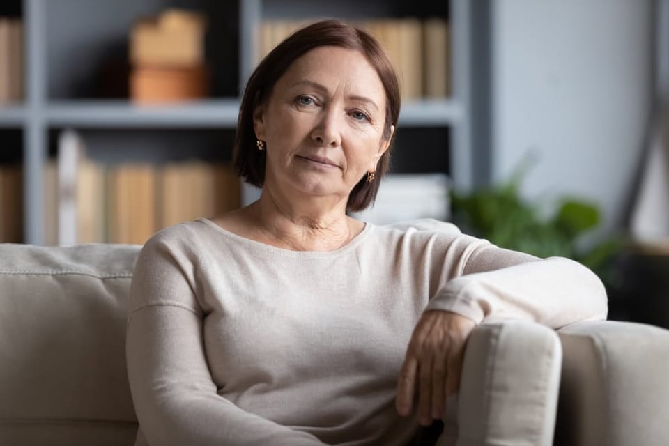 A beautiful middle aged woman sitting on the couch