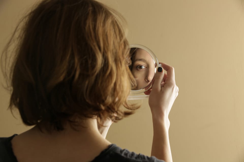 Woman looking into a mirror.