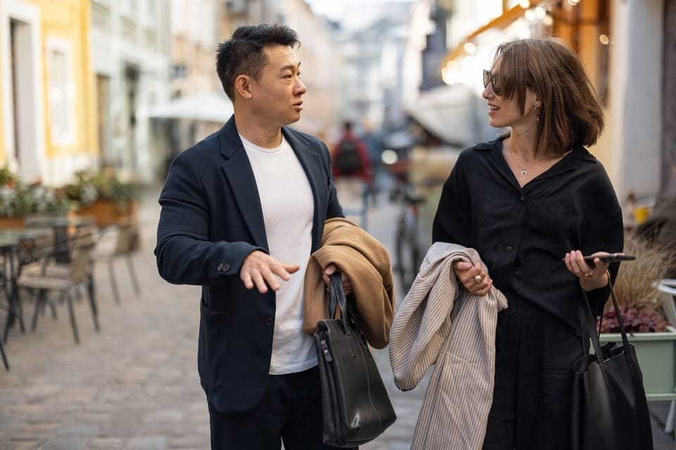 Two colleagues walking on the street talking.