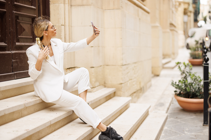 fashionable woman taking selfie on stairs
