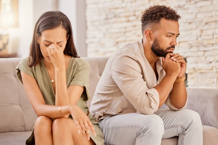 Unhappy couple sitting on couch.