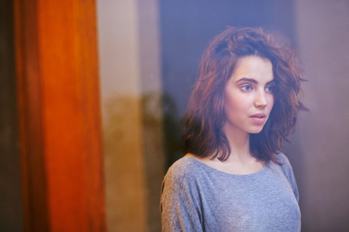 brunette thinking near a window
