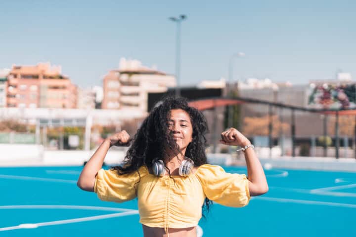 woman flexing bicep muscles outdoors