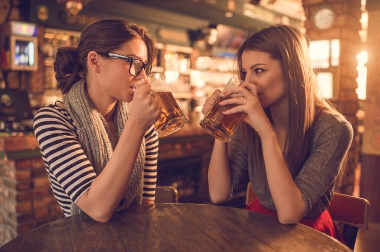 Female friends drinking beer at bar