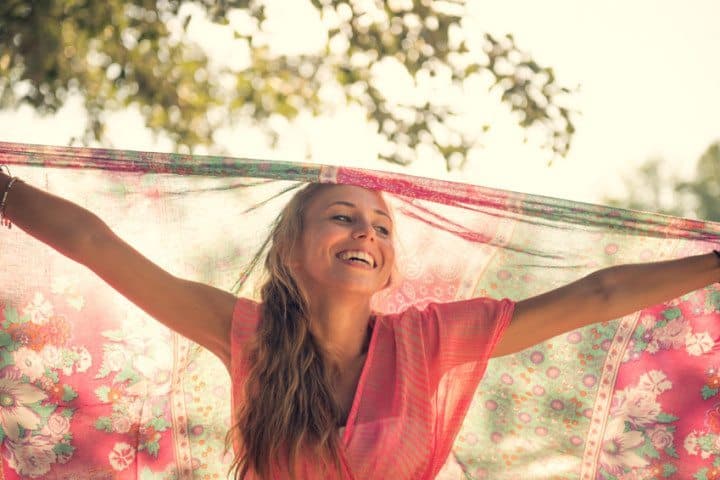 Woman with scarf smiling in park