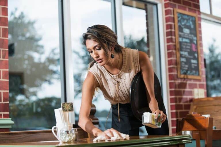 waitress cleaning table at cafe