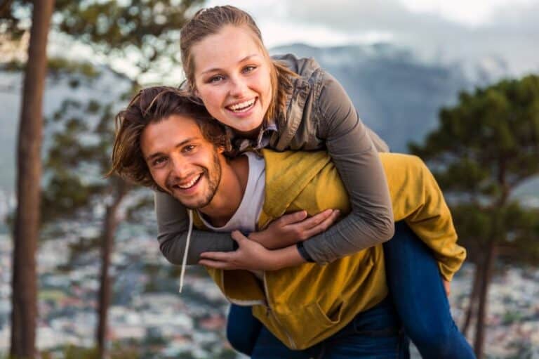 couple giving piggy back ride outdoors