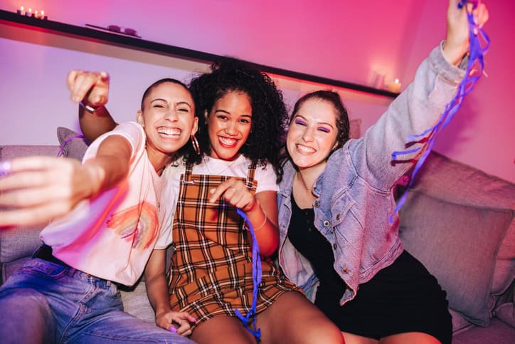 Three girlfriends having a good time at a house party.