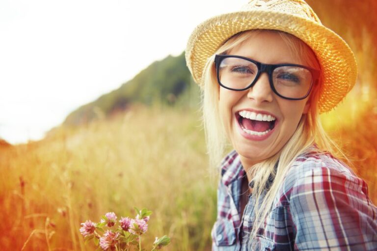 Smiling woman in glasses in field
