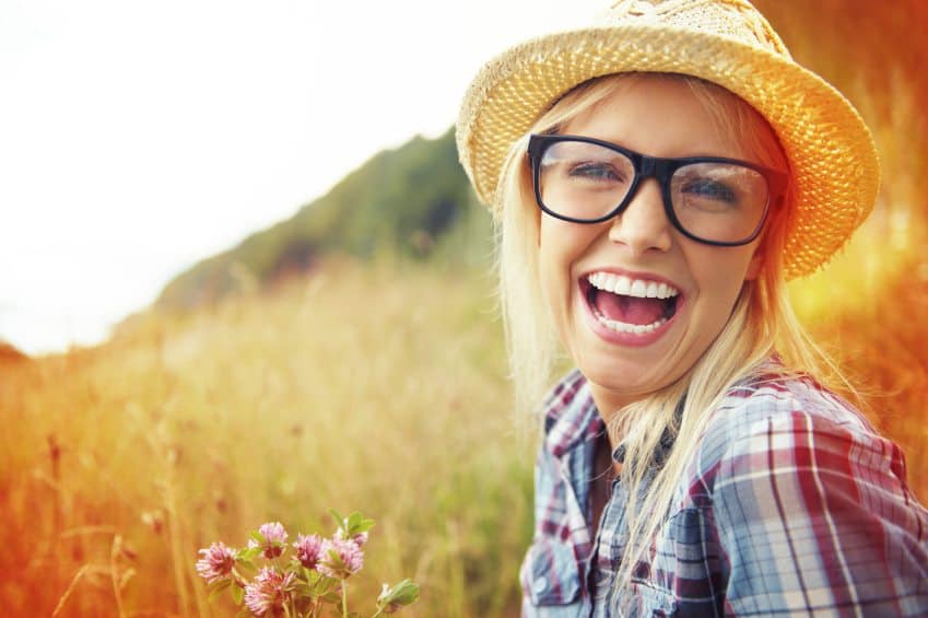 Smiling woman in glasses in field