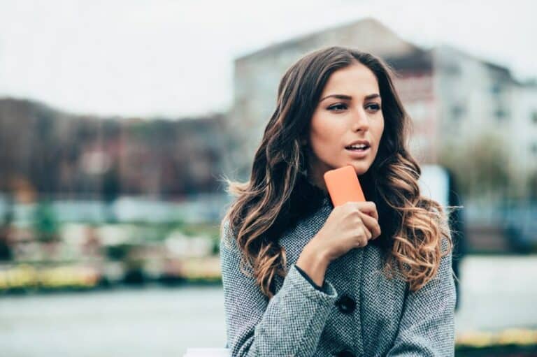 worried woman outdoors with phone