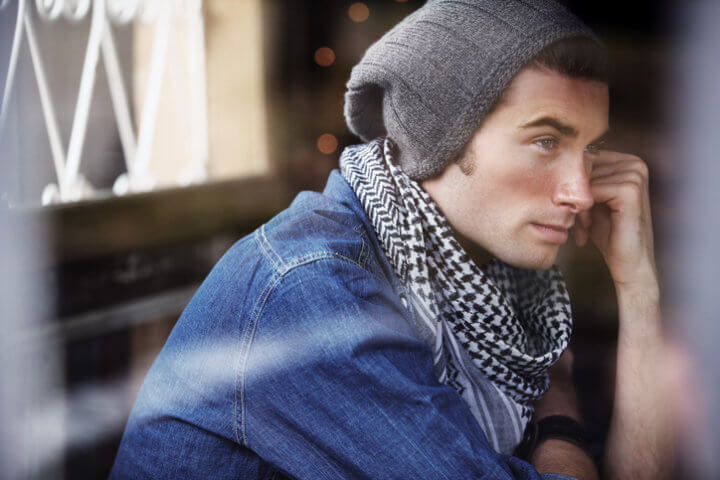A young man resting on his arm as he thinks
