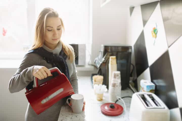 Attractive woman brew tea at her kitchen
